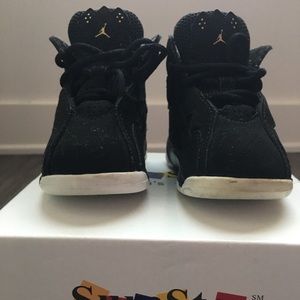 Size 4c Air Jordan black and gold shoes.